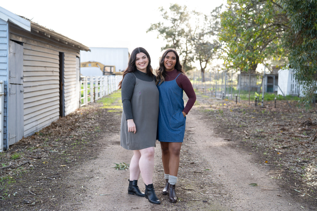 Two models wear the Marri slip dress styled over a Rowan turtleneck, with boots and scrunchy socks, 90s style
