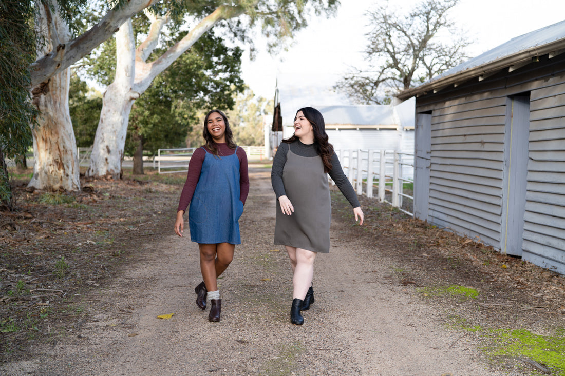 Two models wear the Marri slip dress styled over a Rowan turtleneck, with boots and scrunchy socks, 90s style