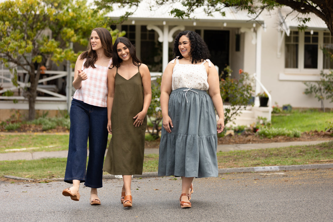 Three models laugh together, two wearing Marri camisoles and one wearing a Marri dress